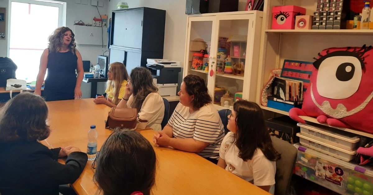 Teresa Vaz a partilhar as suas experiência com um grupo de formandas à volta de uma mesa comprida