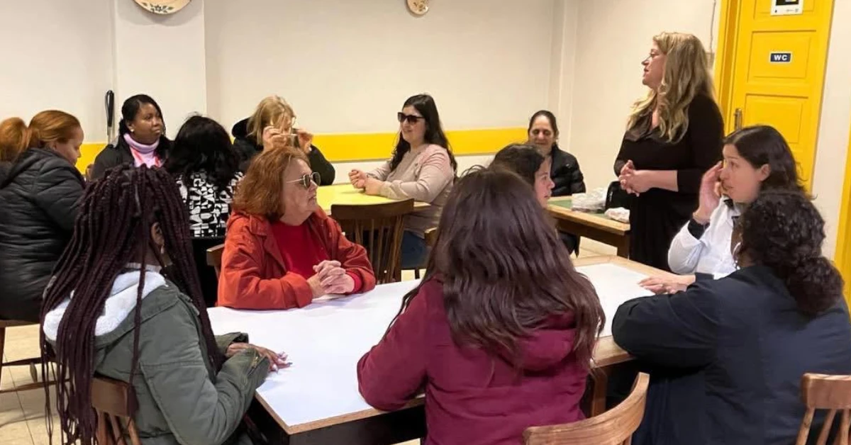As formandas agrupadas em mesas assistem à apresentação da Teresa Vaz